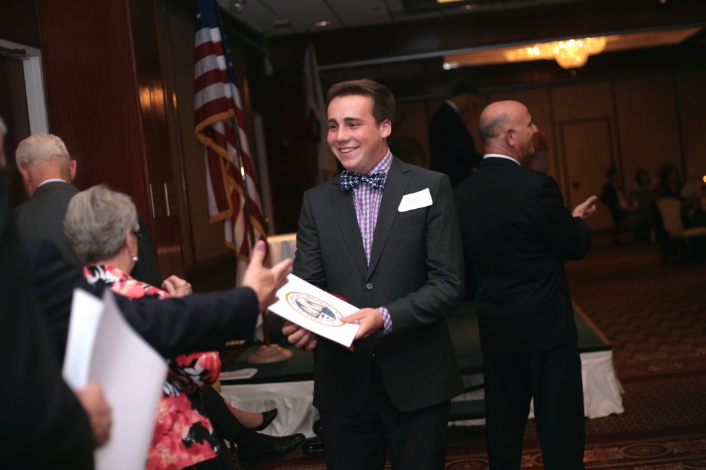 Newport Harbor High School senior Wyatt Robertson gets congratulated by city, school and chamber officials at the Newport Beach Chamber of Commerce Scholarship Awards event on Wednesday. Robertson said his most memorable high school moments were being elected ASB president and playing Willy Wonka in the homecoming rally. He plans on studying physics at Harvard University. — Photo by Sara Hall